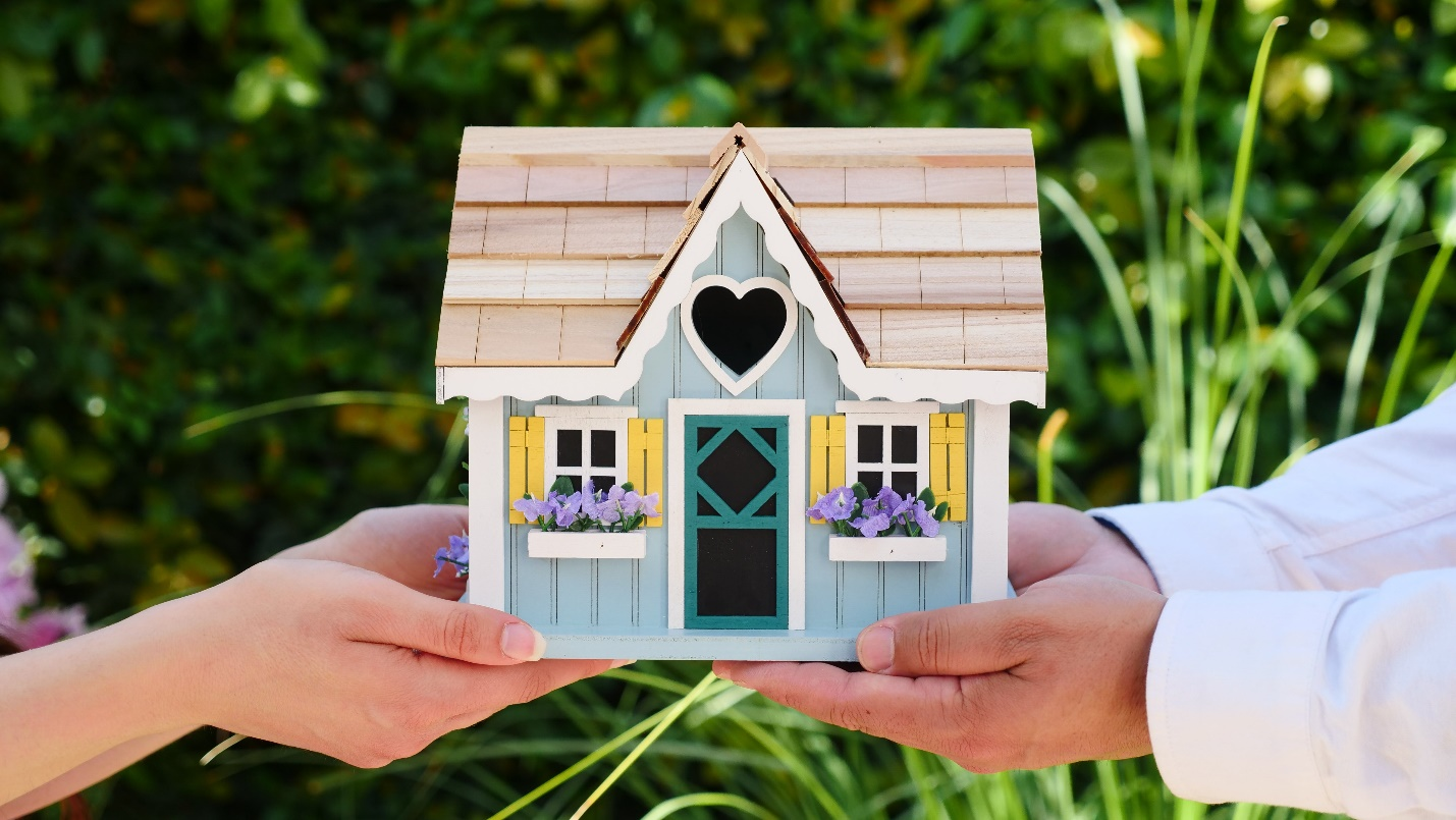 Real Estate Agents Holding a Miniature House